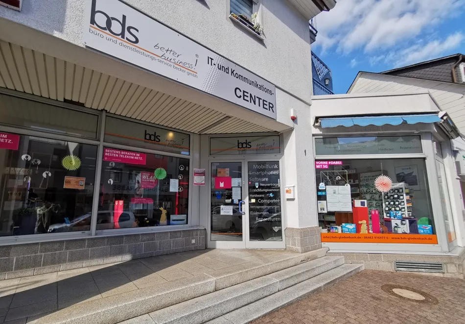 Eingang eines IT- und Kommunikationscenters mit Schaufenstern für Mobilfunk und Computer.
